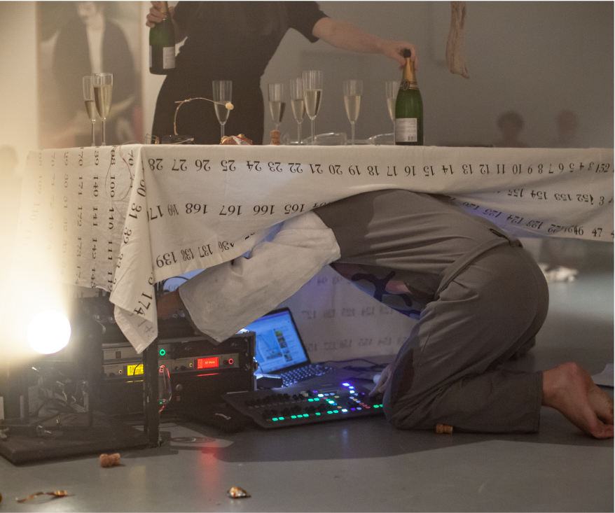 Garret Nelson under a tablecloth working with electronics.