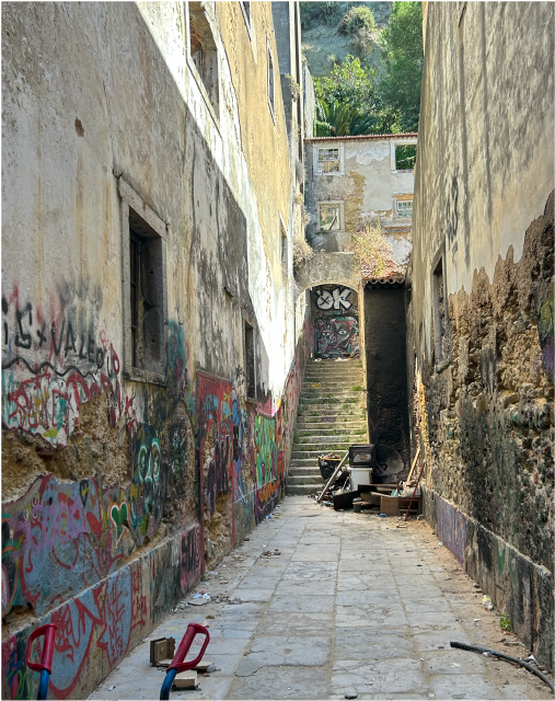 Narrow alley with grafitti and stairs in the back